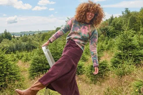 White Stuff AW24 campaign image - woman in knitwear and dress