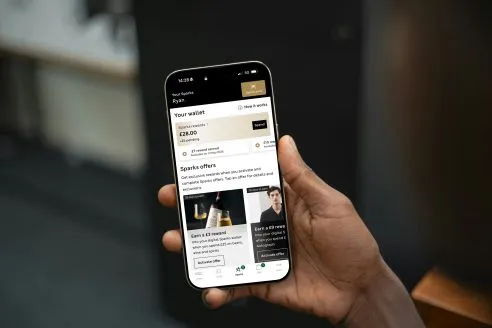 A hand holding a phone opened on the M&S Sparks app