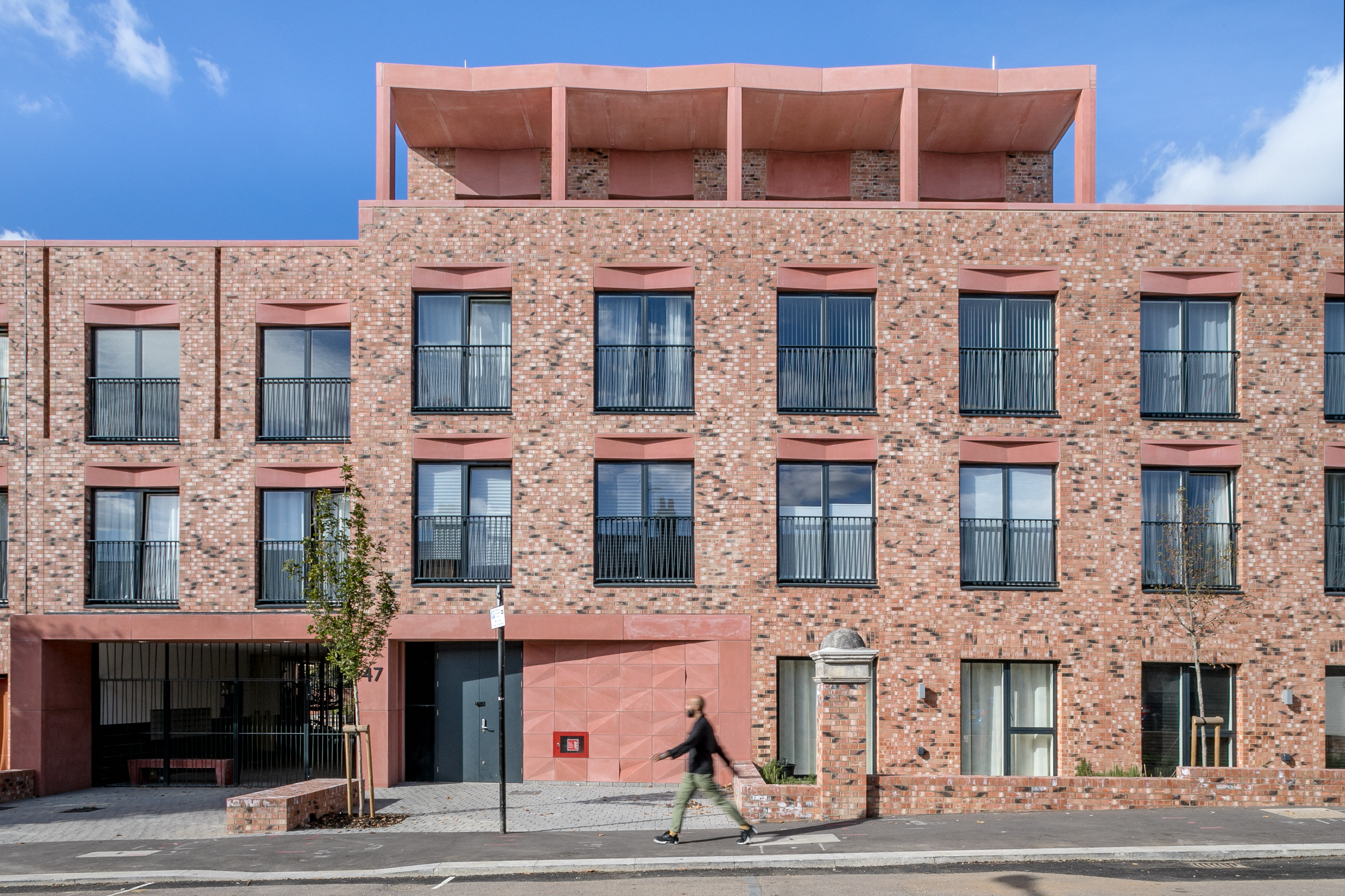 Terracotta-coloured concrete accents Pocket Living apartment block by ...